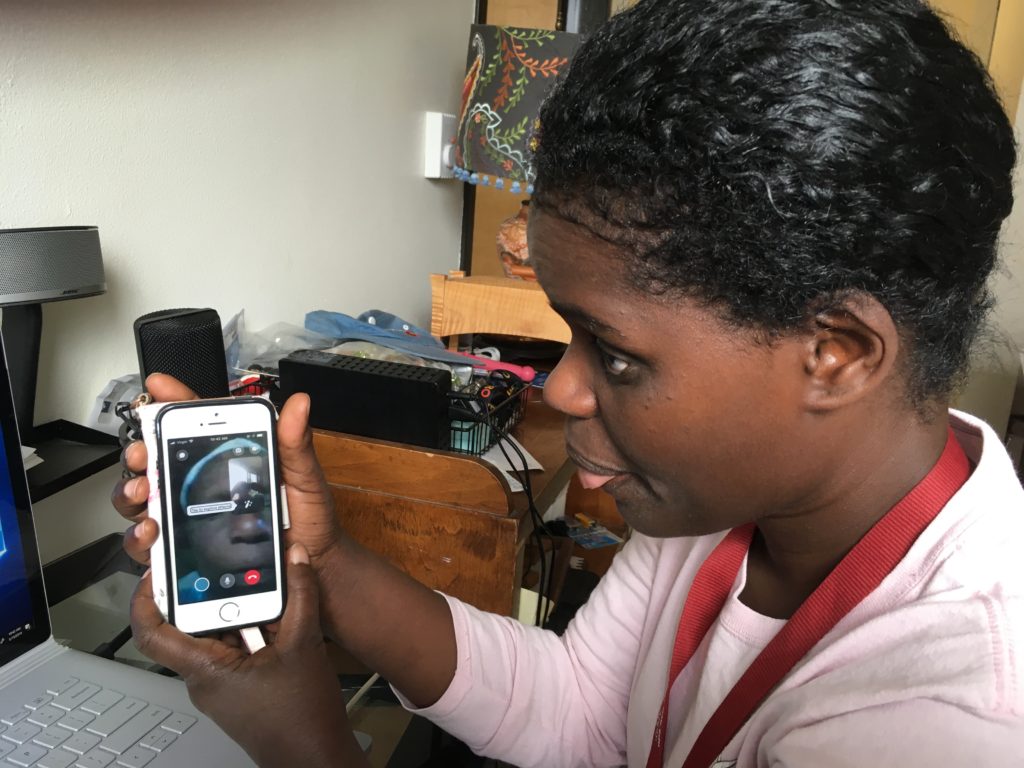 Abby holds her cell phone that shows her mother in Ethiopia during a facebook call to her mother in Ethiopia.
