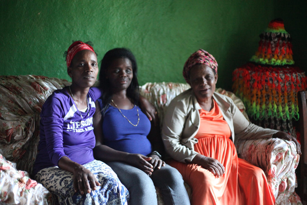 Abby sits with her mother and sister in Ethiopia